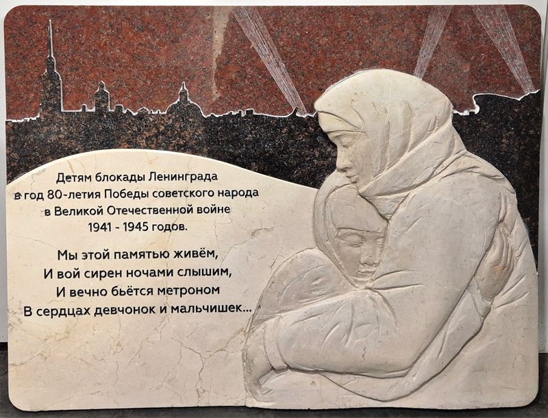 Красный гранит с белым барельефом и силуэтом Ленинграда