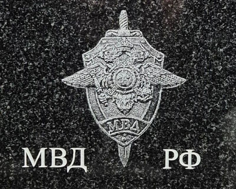 гравировка эмблемы МВД РФ (двуглавый орёл с мечом) и надпись «МВД РФ» на чёрном крапчатом граните
