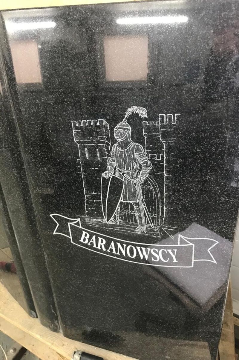 Чёрная полированная стела с гравировкой родового герба, снята в цехе